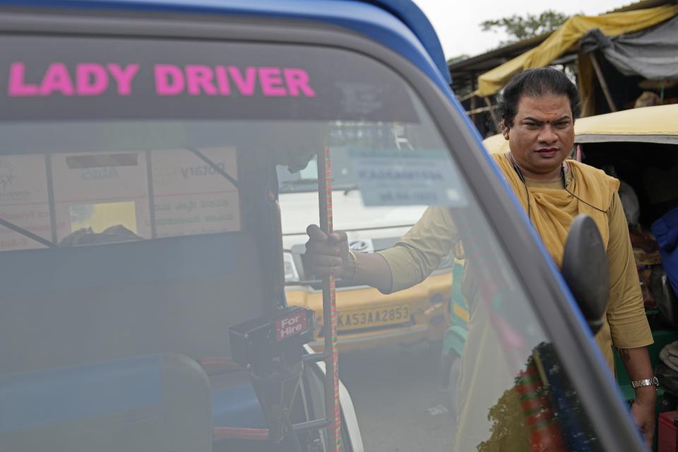 Preethi, a 38-year-old transgender woman who uses only her first name, waits for customers to ferry in her electric auto rickshaw on a busy street in Bengaluru, India, Wednesday, July 12, 2023. “I have regular customers who range from vegetable vendors to mothers in my neighborhood who prefer to send their daughters to schools and colleges with me,” said Preethi. (AP Photo/Aijaz Rahi)