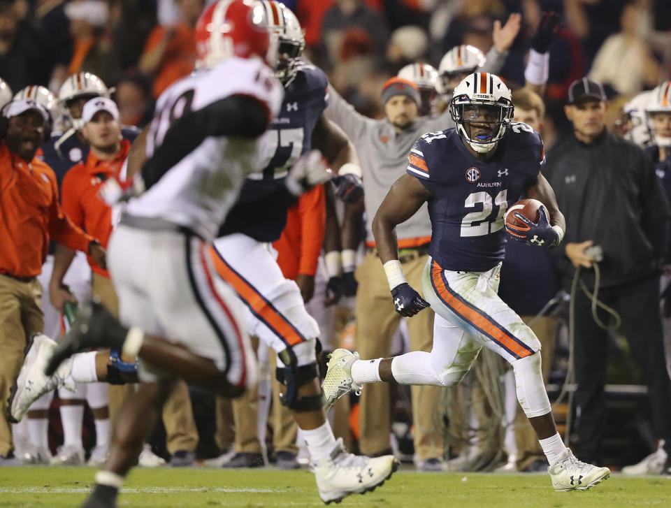 FILE – In this Nov. 11, 2017, file photo, Auburn running back Kerryon Johnson, right, breaks away from Georgia defenders for a touchdown run. (Curtis Compton/Atlanta Journal-Constitution via AP, File)