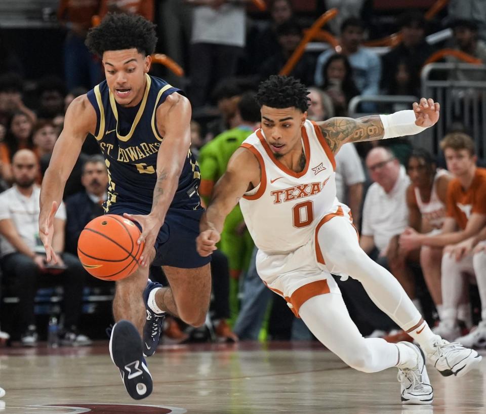 Texas guard Chris Johnson, right, fights for the ball against St. Edward's Jayden Johnston during a scrimmage in October. Johnson has entered his name in the transfer portal, according to multiple reports. Teas officials could not confirm the news Tuesday.