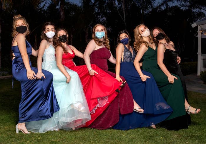 Modern teen girls wearing masks and brightly colored modern dresses