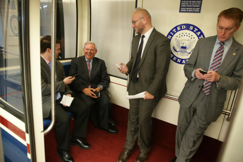 Sen. Robert Menendez (D-N.J.), second from left, smiles as he rides a Senate subway with a member of the press, left, after a vote April 23, 2015, to confirm Loretta Lynch as the next U.S. attorney general.