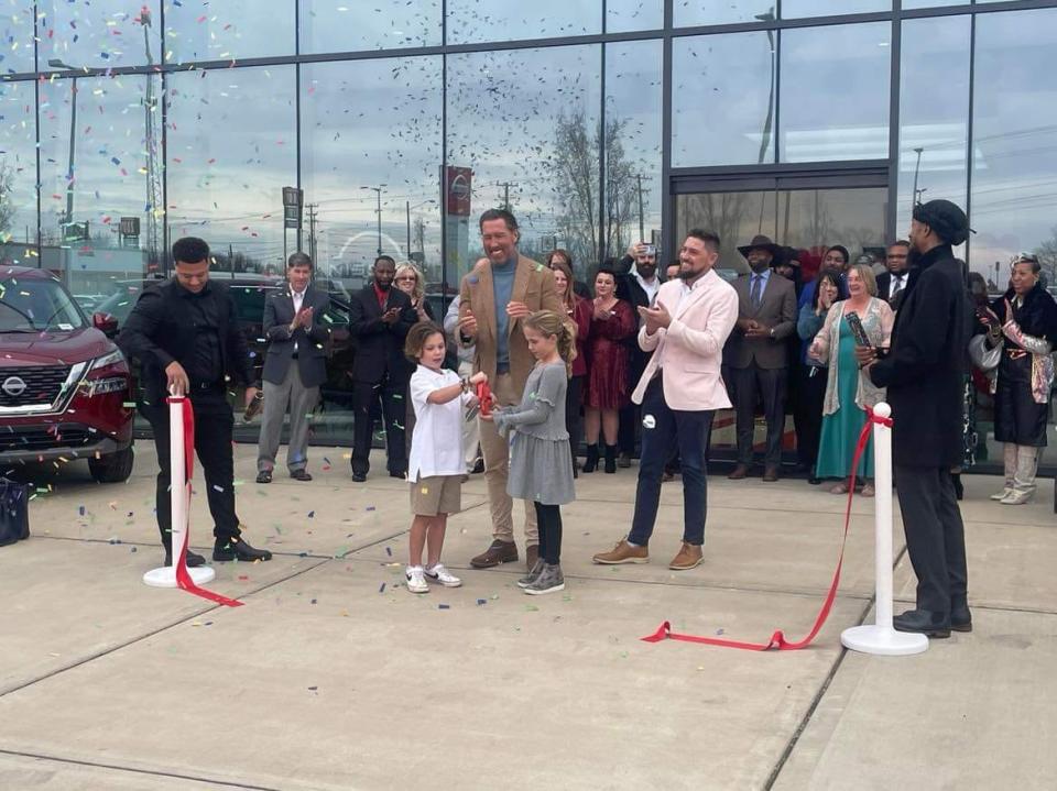 Kevin Geagan, new owner of Discovery Nissan, and a crowd gathered at the grand opening Friday.