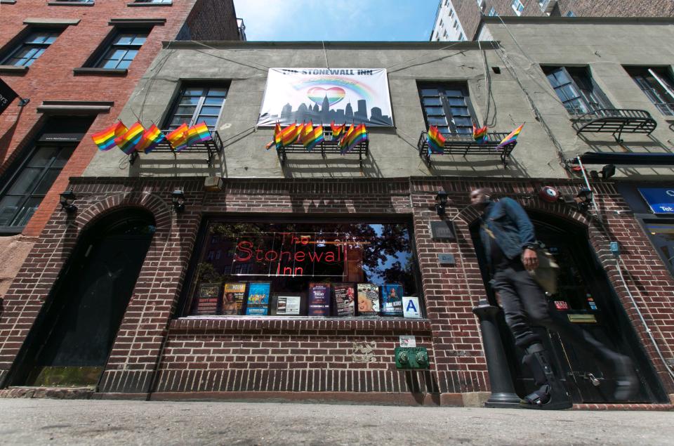 FILE - In this May 29, 2014 file photo, a man passes The Stonewall Inn in New York's Greenwich Village. The bar was the site of the Stonewall uprising that started on June 28, 1969 and galvanized the Gay Rights Movement. June 2019 Pride Month marks the 50th Anniversary of the Stonewall uprising, with events that commemorate that moment and its impact through the last five decades. (AP Photo/Richard Drew, File)