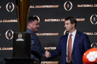 LSU head coach Ed Orgeron, left, and Clemson head coach Dabo Swinney shake hands after a news conference for the NCAA College Football Playoff national championship game Sunday, Jan. 12, 2020, in New Orleans. Clemson is scheduled to play LSU on Monday. (AP Photo/David J. Phillip).