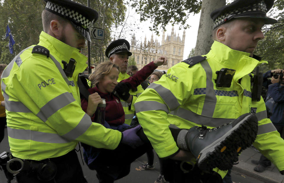 A demonstrator is arrested by police officers during in a climate protest near Parliament in London, Tuesday, Oct. 8, 2019. Police are reporting they have arrested more than 300 people at the start of two weeks of protests as the Extinction Rebellion group attempts to draw attention to global warming. (AP Photo/Kirsty Wigglesworth)