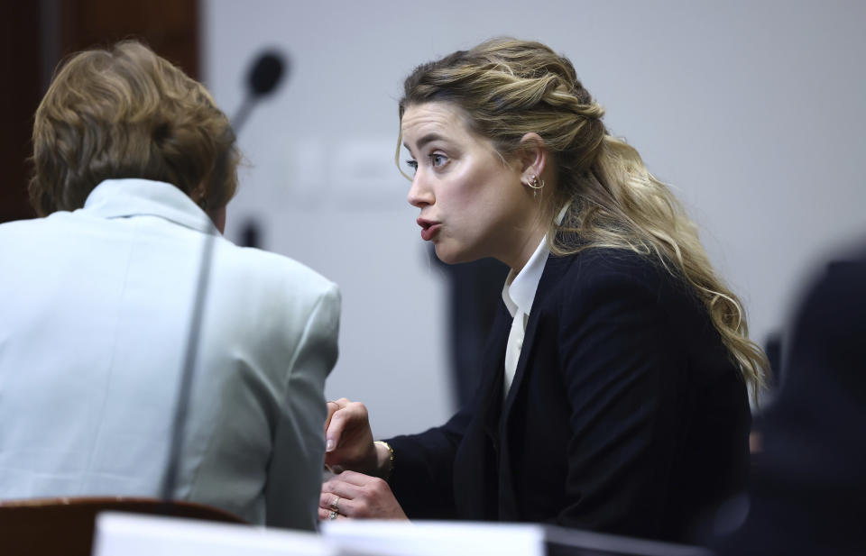 Actor Amber Heard speaks with her legal team in the courtroom at the Fairfax County Circuit Court in Fairfax, Va., Thursday, April 21, 2022. Actor Johnny Depp sued his ex-wife Amber Heard for libel in Fairfax County Circuit Court after she wrote an op-ed piece in The Washington Post in 2018 referring to herself as a "public figure representing domestic abuse." (Jim Lo Scalzo/Pool Photo via AP)
