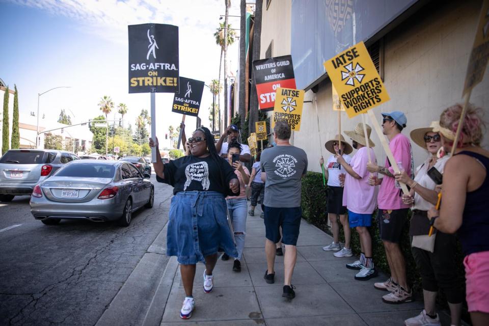 Black woman holding a picket sign