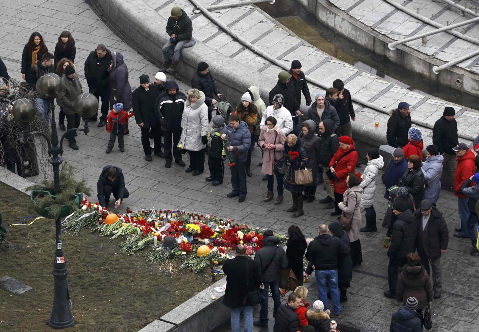 People lay flowers in memory of anti-government protesters killed in recent clashes in the Independence Square in Kiev