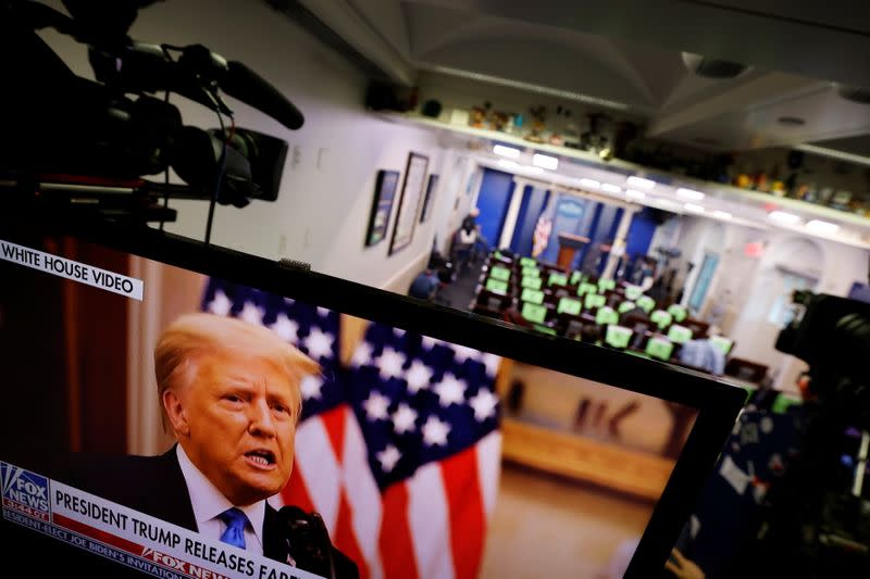 Trump makes remarks on TV monitor from White House Briefing Room during his last day in office, in Washington