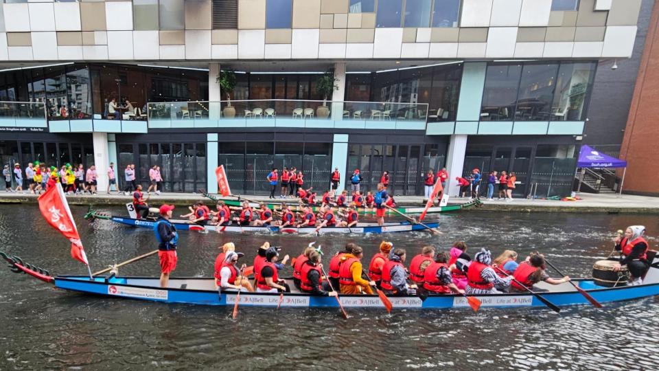 rowers in red life jackets on boats in the canal