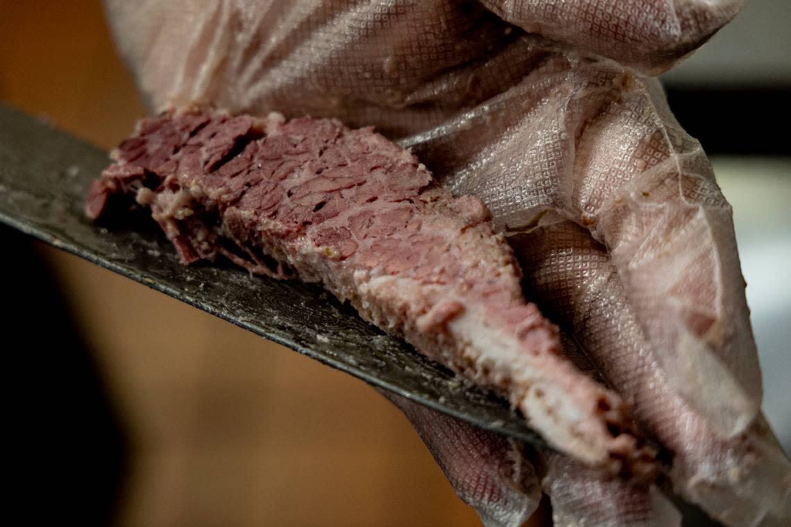 Drew Kalagher cuts thick slices of corned beef brisket. He makes his own corned beef at Publick House.