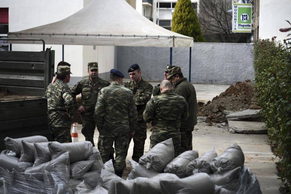 Military officers stand at a gas station in the northern Greek city of Thessaloniki, on Thursday, Feb. 9, 2016 where an unexploded World War II bomb was found 5 meters (over 16 feet) deep. Authorities in Greece's second-largest city on Sunday are planning to evacuate up to 60,000 residents from their homes so experts can safely dispose of the unexploded World War II bomb. (AP Photo/Giannis Papanikos)