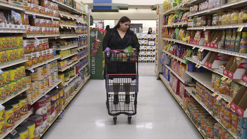 <em>Jaqueline Benitez pushes her cart down an aisle as she shops for groceries at a supermarket in Bellflower, Calif., on Monday, Feb. 13, 2023.</em> (AP Photo/Allison Dinner)
