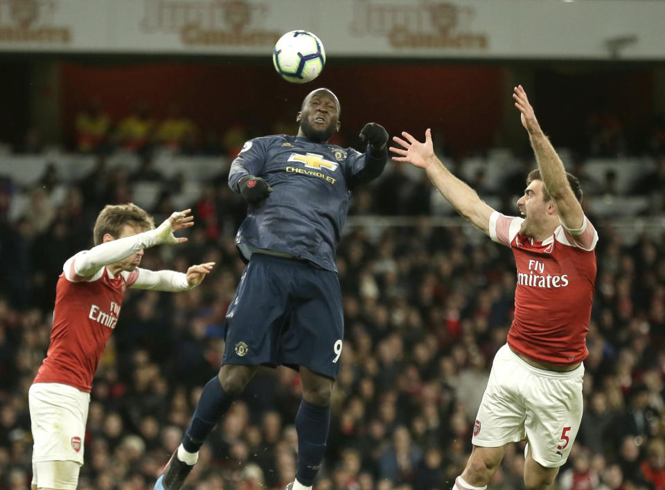 Arsenal's Nacho Monreal, left, Arsenal's Sokratis Papastathopoulos, right, and Manchester United's Romelu Lukaku challenge for the ball during the English Premier League soccer match between Arsenal and Manchester United at the Emirates Stadium in London, Sunday, March 10, 2019. (AP Photo/Tim Ireland)