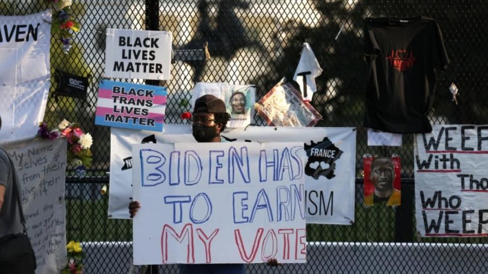In this photo from August 2020, a demonstrator holds a sign referring to then-Democratic presidential nominee Joe Biden at Black Lives Matter Plaza in Washington. As the president seeks to retain his seat, he has assembled a diverse advisory board. (Photo: Michael M. Santiago/Getty Images)