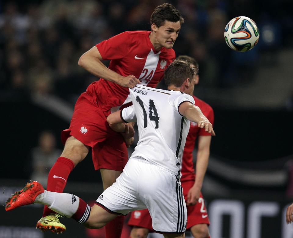 Germany's Oliver Sorg, right, and Poland's Jakub Wawrzyniak, left, challenge for the ball during a friendly soccer match between Germany and Poland in Hamburg, Germany, Tuesday, May 13, 2014. (AP Photo/Michael Sohn)