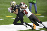 New Orleans Saints wide receiver Tre'Quan Smith, left, is hit by Tampa Bay Buccaneers defensive back Ross Cockrell (43) as Smith scores a touchdown during the second half of an NFL divisional round playoff football game, Sunday, Jan. 17, 2021, in New Orleans. (AP Photo/Butch Dill)