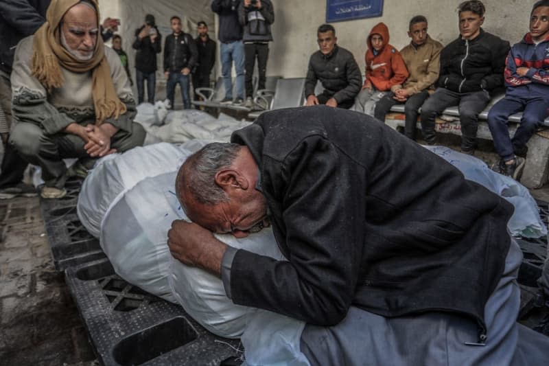 Palestinians mourn next to the bodies of their relatives, who were killed during an Israeli air strike on a house belonging to the Zamili family in the city of Rafah in the southern Gaza Strip, at Al-Najjar Hospital. Abed Rahim Khatib/dpa