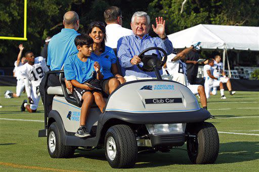 Carolina Panthers owner Jerry Richardson, front right, South Carolina Gov. Nikki Haley, center, and her son Nalin Haley, left, greet fans during practice at the NFL team's football training camp in Spartanburg, S.C., Monday, July 30, 2012. (AP Photo/Chuck Burton)