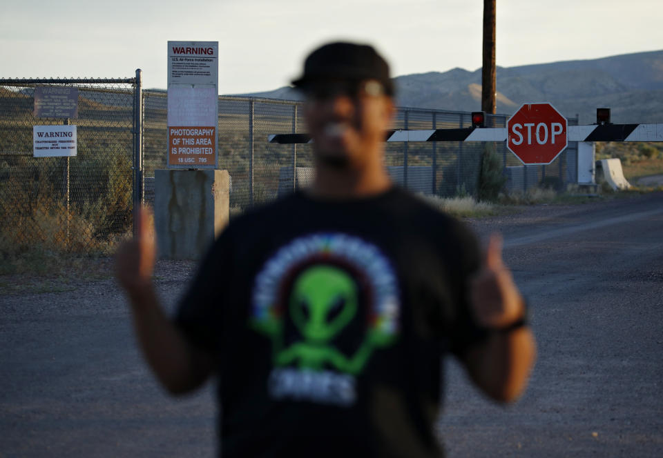 In this July 22, 2019 photo, Stan Evans poses as he has his picture taken while visiting an entrance to the Nevada Test and Training Range near Area 51 outside of Rachel, Nev. The U.S. Air Force has warned people against participating in an internet joke suggesting a large crowd of people "storm Area 51," the top-secret Cold War test site in the Nevada desert. (AP Photo/John Locher)