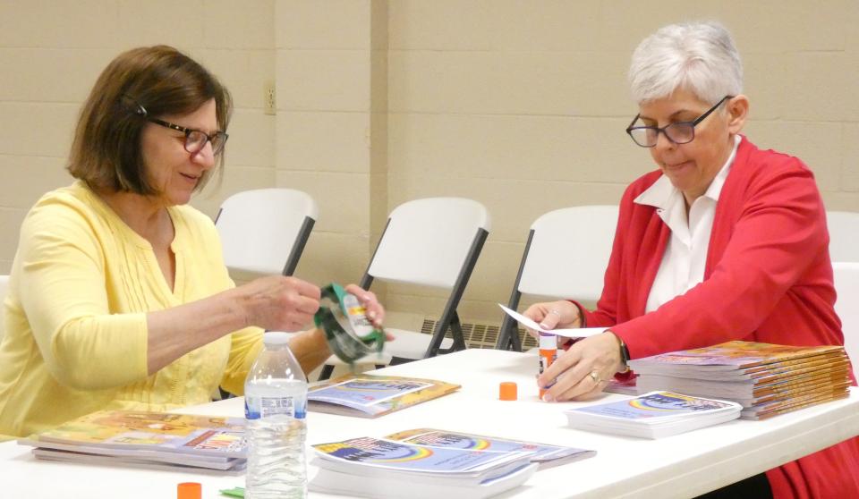 Pam Holtshouse, left, and Major Debbra Grace of the Bucyrus Salvation Army prepare coloring books for shipment to Ukrainian refugees.