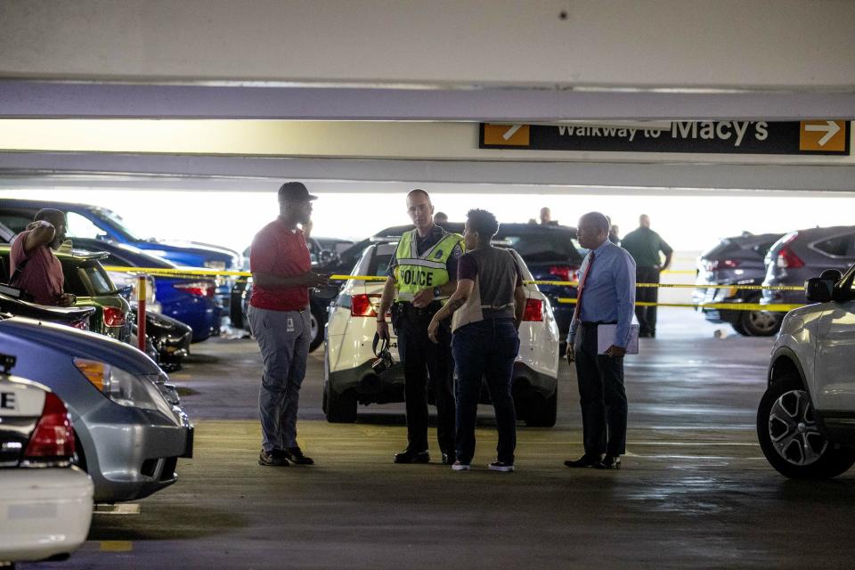 Police officers stand at a crime scene following a shooting at the parking garage for the Fashion Centre at Pentagon City, also known as Pentagon City Mall, Monday, July 1, 2019, in Arlington. (AP Photo/Andrew Harnik)