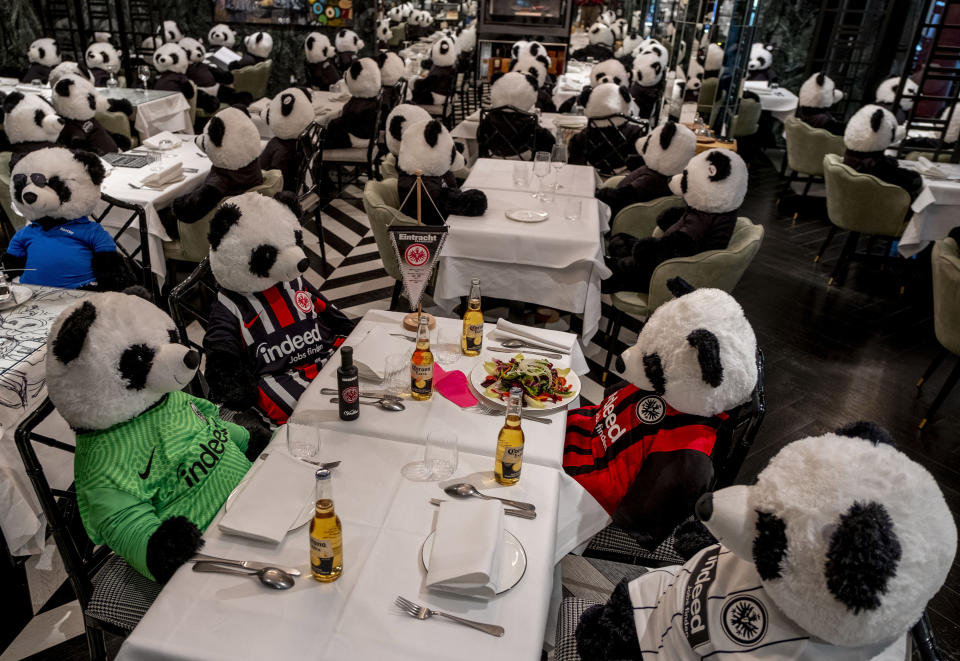 FILE - In this Nov. 24, 2020 file photo, plush pandas and Corona beer bottles decorate the tables of a closed restaurant in Frankfurt, Germany. Restaurants all over Germany were closed as a partial lockdown began in November to avoid the further outspread of the coronavirus. More than 50,000 people have died after contracting COVID-19 in Germany, a number that has risen swiftly over recent weeks as the country has struggled to bring down infection figures. (AP Photo/Michael Probst, File)