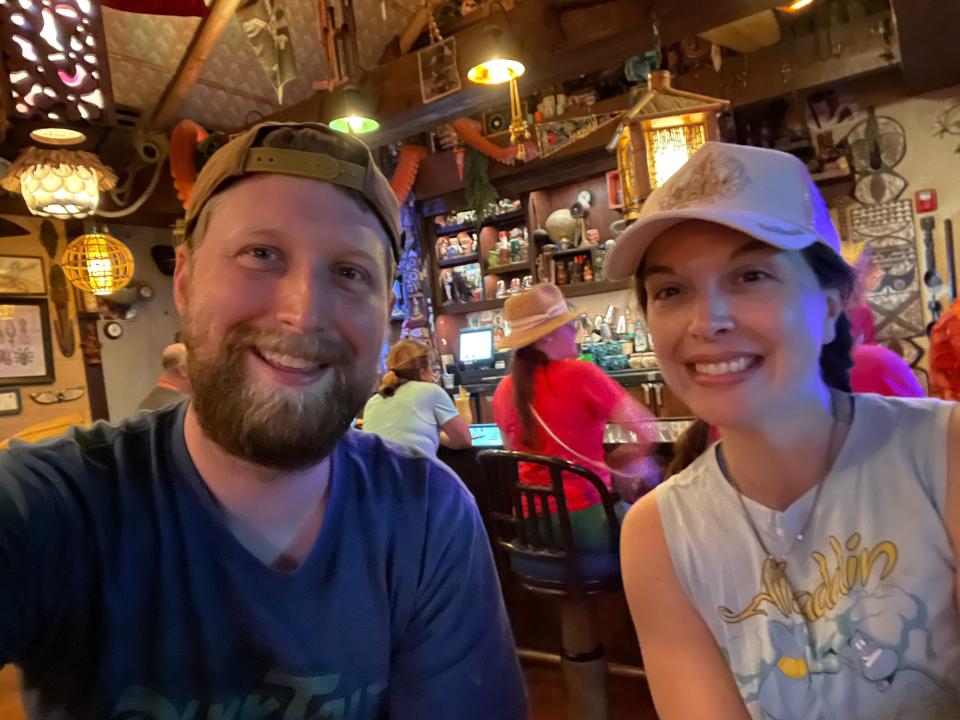 tim and cat posing for a selfie inside trader sams at the polynesian resort