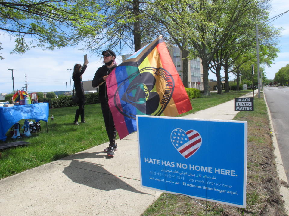 A demonstrator who would not identify herself holds a flag during a protest in Neptune N.J., Friday, May 7, 2021, against a school vice principal who was filmed tossing beer at people who were videotaping his wife's rant against a transgender woman's use of a public restroom at an outdoor restaurant in Galloway Township N.J. in April. (AP Photo/Wayne Parry)