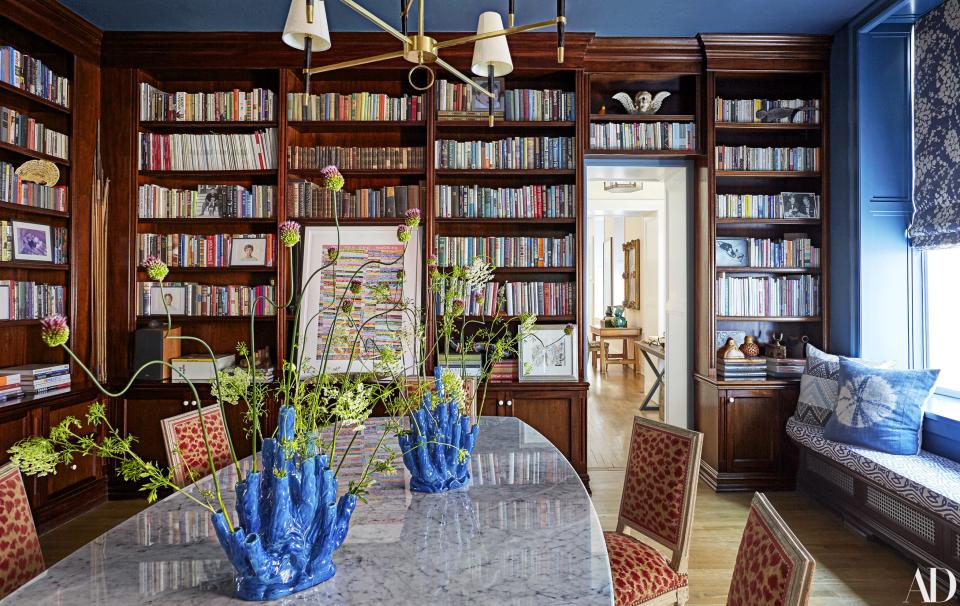 Custom mahogany bookshelves line Patricia Herrera Lansing’s New York City dining room. Custom table; vintage dining chairs; Peter Davies artwork.