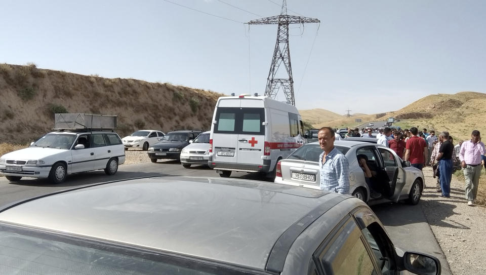 In this photo taken on Sunday, July 29, 2018, an ambulance arrives where four tourists were killed when a car rammed into a group of foreigners on bicycles south of the capital of Dushanbe, Tajikistan. The Islamic State group on Tuesday claimed responsibility for a car-and-knife attack on Western tourists cycling in Tajikistan that killed two Americans and two Europeans. (AP Photo/Zuly Rahmatova)