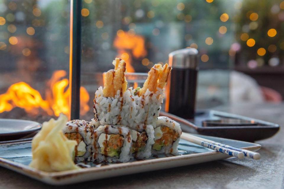 A platter of vegetarian sushi roll rests near an outdoor fire pit at Prime Social in Kansas City.