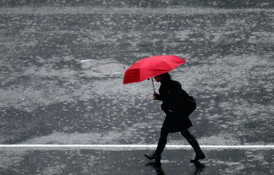 A pedestrian crosses in the intersection of Queen Street and Victoria Street during heavy rain on July 1, 2014 in Auckland, New Zealand: Jason Oxenham/Getty Images