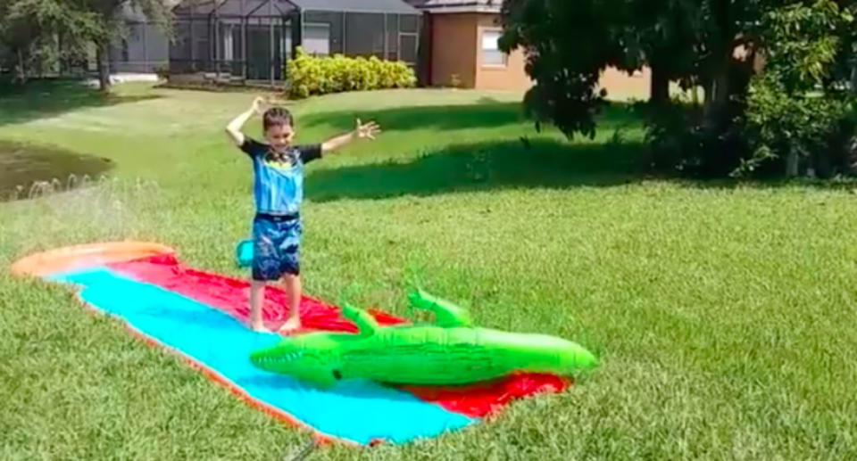 Timmy was playing on a slip and slide when the alligator was watching him. Source: Facebook/Nicole Mojica