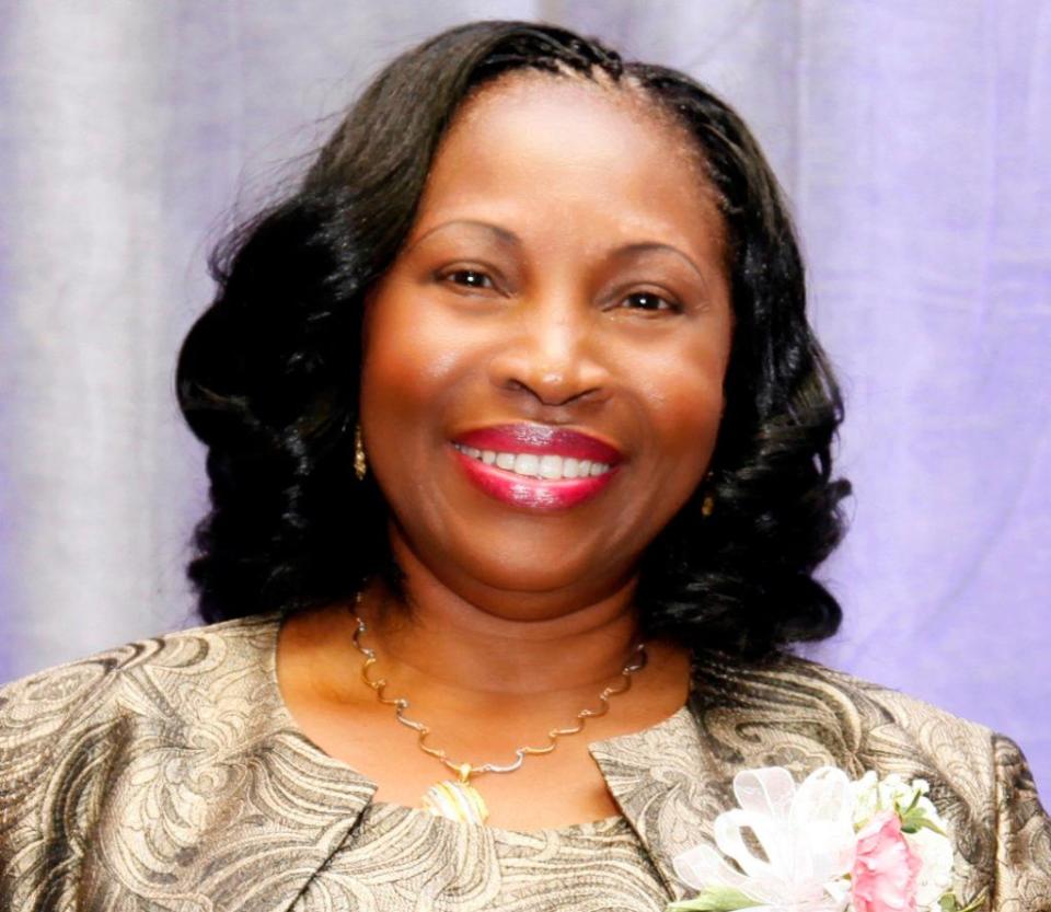 An African American woman with black hair, smiling. 