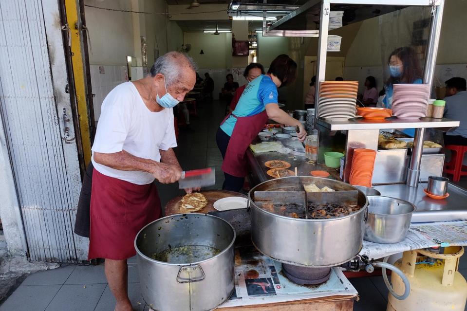 Ong Tai Buan prepares the side dishes to be served to customers at his stall placed prominently in front of the shop along Muntri Street in George Town February 24, 2021. — Pictures by Steven Ooi KE