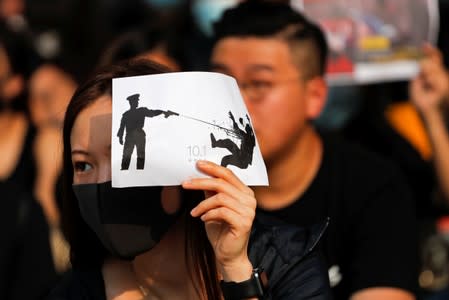 An alumna of Tsuen Wan Public Ho Chuen Yiu Memorial College participates in a student gathering in the school in solidarity with the student protester who was shot by a policeman on Tuesday in Tsuen Wan