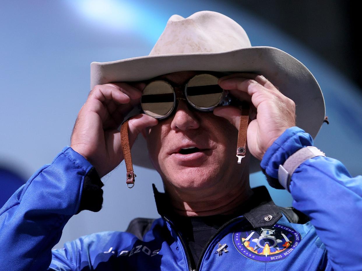 Blue Origin founder Jeff Bezos wears a pair of reflective aviation glasses under a cowboy hat