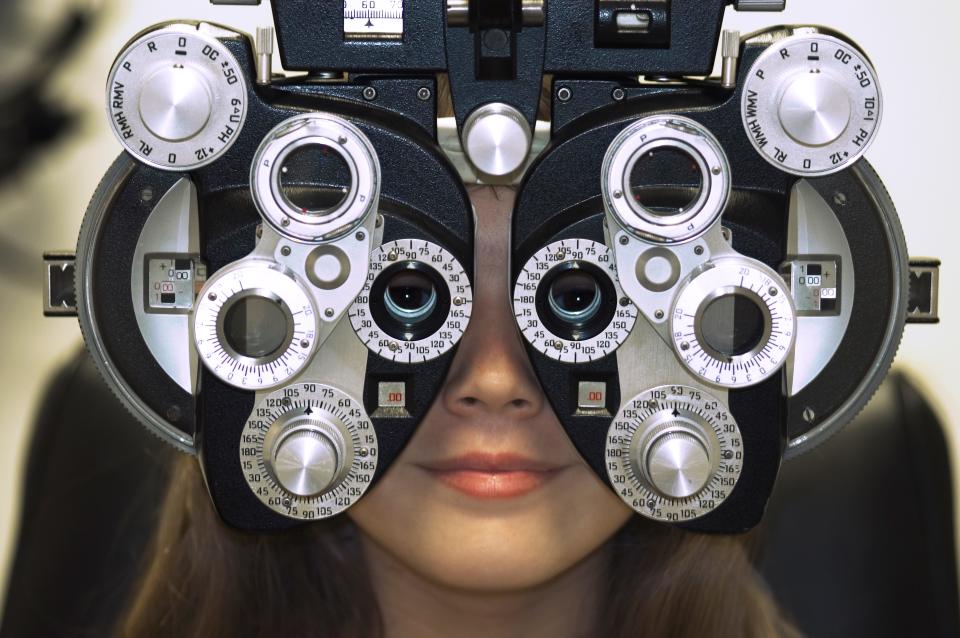 Woman's Face Behind Eye Exam Machine