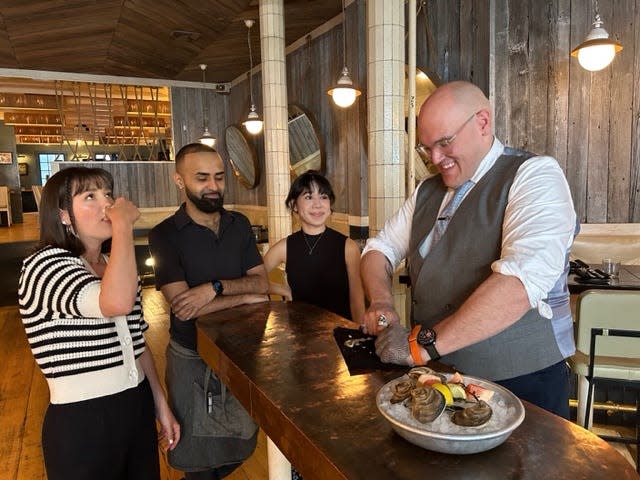 Jeremy Benson shucks a number of Blue Point oysters for fellow workers at Crave Fishbar in New York. Benson is looking to become the first certified master oyster sommelier, or mermmelier.