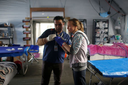 Foreign and local volunteers work at the emergency field hospital which is run by the US Christian charity Samaritan's Purse, eastern Mosul, Iraq March 22, 2017. Picture taken March 22, 2017. REUTERS/Suhaib Salem