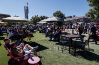 Fans eat and watch the big screen before the NASCAR Cup Series auto race Sunday, Oct. 2, 2022, in Talladega, Ala. (AP Photo/Butch Dill)