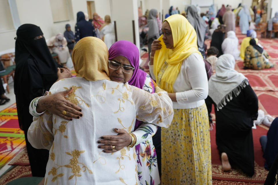 Sudanese community members, Ronya Salih, in the pink hijab, and Shaza Ahmed, in the gold hijab, embrace and comfort each other as they gather for Eid al-Fitr, Friday, April 21, 2023, at the Muslim Community Center in Silver Spring Md. Eid al-Fitr marks the end of the Islamic holy month of Ramadan. For the Sudanese community in Maryland, Eid celebrations have been tempered with concern for the homeland. Standing left is Ranai Ali, and standing right is Sahar Ali. (AP Photo/Carolyn Kaster)