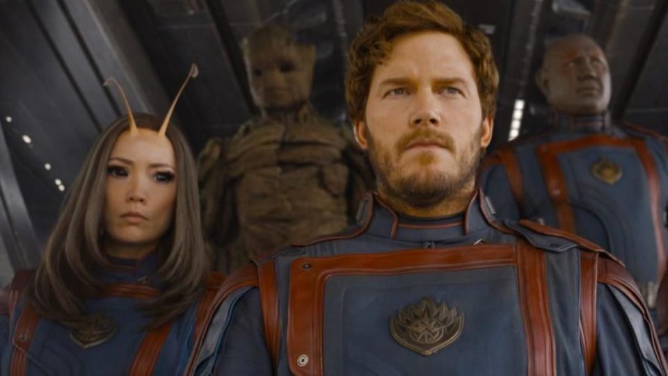 guardians of the galaxy team in matching suits sit together in a spaceship