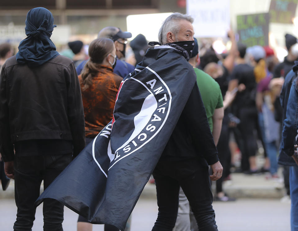 Hundreds of protesters, including a man with an ANTIFA flag draped over his shoulders, gather in Boston on May 31, 2020 during a rally sponsored by the Youth of Greater Boston to demand justice for George Floyd and support the Black Lives Matter movement. (Matthew J. Lee/The Boston Globe via Getty Images)