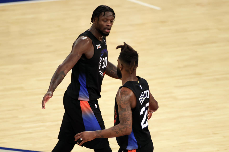 New York Knicks forward Julius Randle, left, reacts with forward Reggie Bullock, right, during the second half of an NBA basketball game against the New Orleans Pelicans on Sunday, April 18, 2021, in New York. (AP Photo/Adam Hunger, Pool)