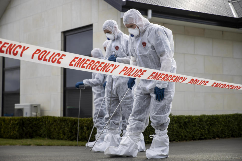 Police search the driveway of a house where three children were found dead in the South Island town of Timaru, New Zealand, Friday, Sept. 17, 2021. Three young children who had just moved to New Zealand from South Africa have died in what police are investigating as homicide. (George Heard/New Zealand Herald via AP)