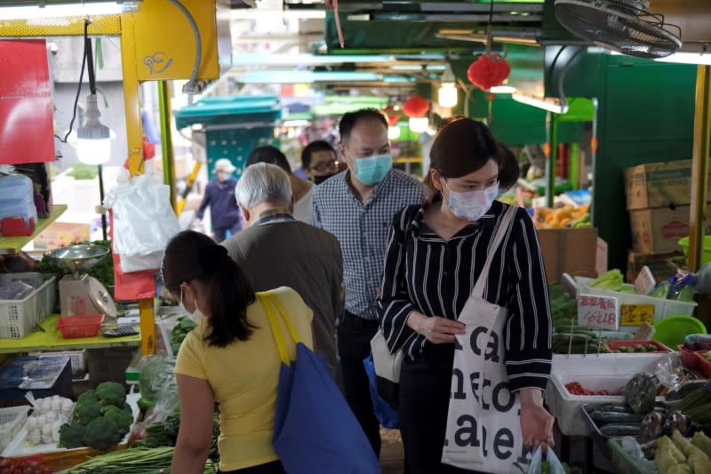 People with protective masks walk at a market at the financial Central district, following the novel coronavirus disease (COVID-19) outbreak, in Hong Kong, China March 27, 2020. REUTERS/Tyrone Siu