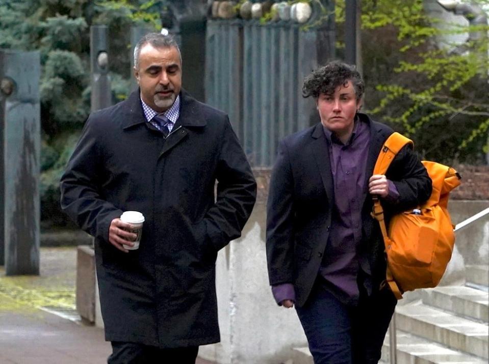 Ottawa firefighter Ash Weaver, right, walks with Sgt. Ali Toghrol of the Ottawa Police Service's hate and bias crime unit near the Ottawa Courthouse on May 8, 2024. 