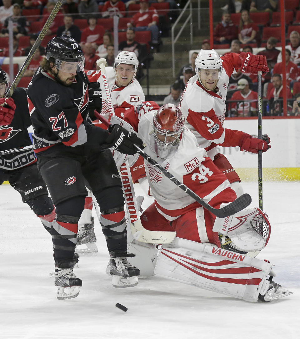 Detroit Red Wings goalie Petr Mrazek (34), of the Czech Republic, blocks Carolina Hurricanes' Justin Faulk (27) during the second period of an NHL hockey game in Raleigh, N.C., Monday, March 27, 2017. (AP Photo/Gerry Broome)